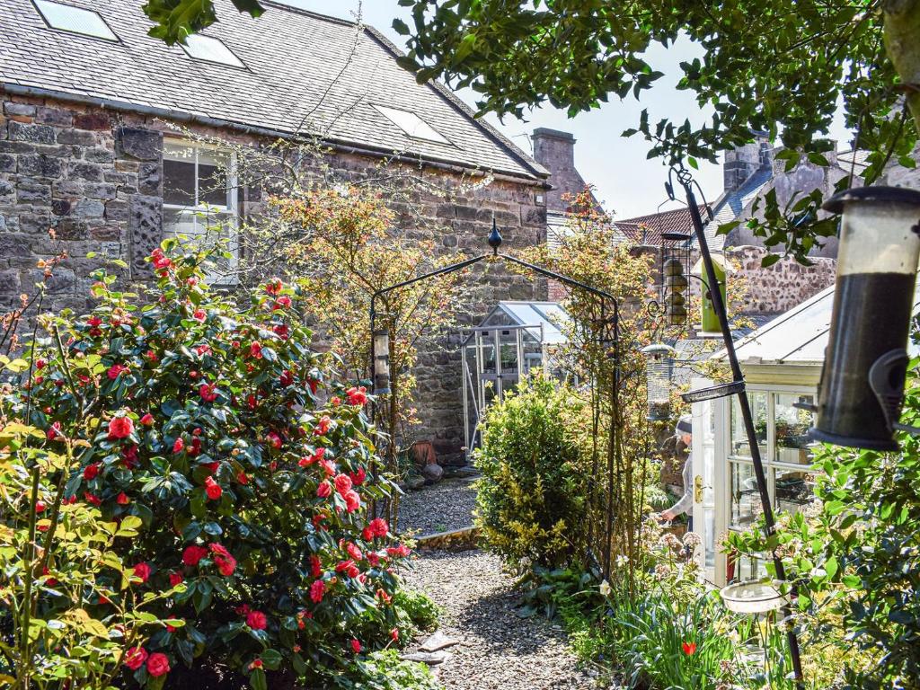 um jardim com rosas em frente a uma casa em St Cuthberts Retreat em Wooler