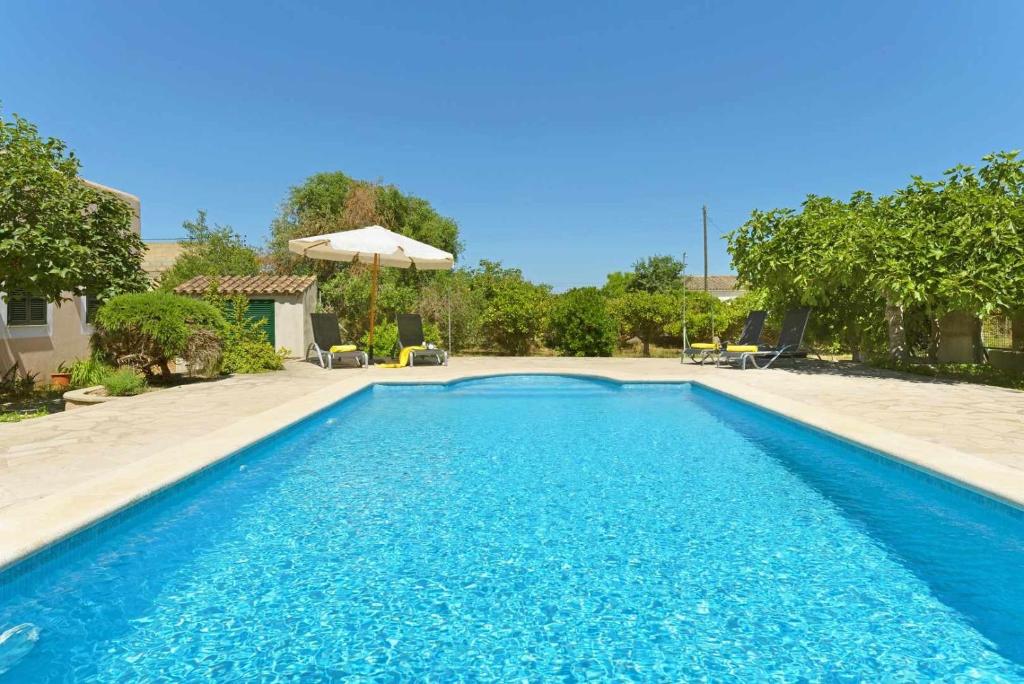 una piscina de agua azul en un patio en BeOnHolidays Villa Sa Fonera, en Maria de la Salut