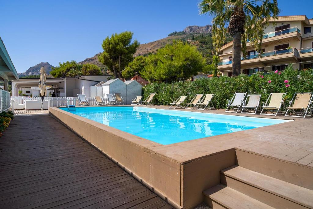 a swimming pool with lounge chairs in a resort at Hotel Rivage Taormina in Taormina
