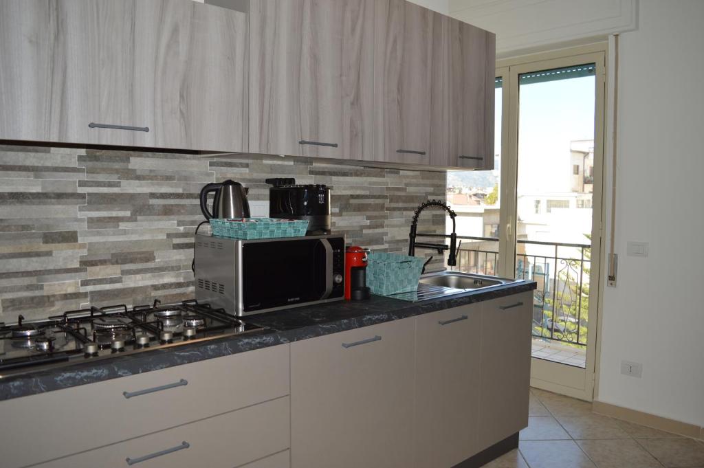 kuchnia ze zlewem i kuchenką górny piekarnik w obiekcie Emerella Guest House Siderno Beach w mieście Siderno Marina
