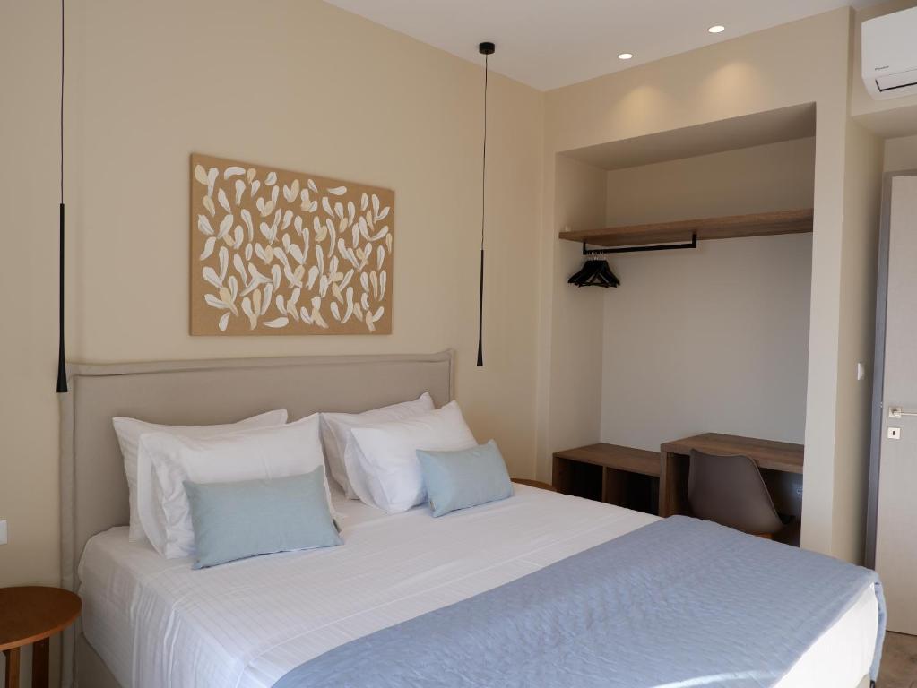 1 dormitorio con 1 cama blanca grande con almohadas azules en Kaiser Luxury Suites, en Achílleion
