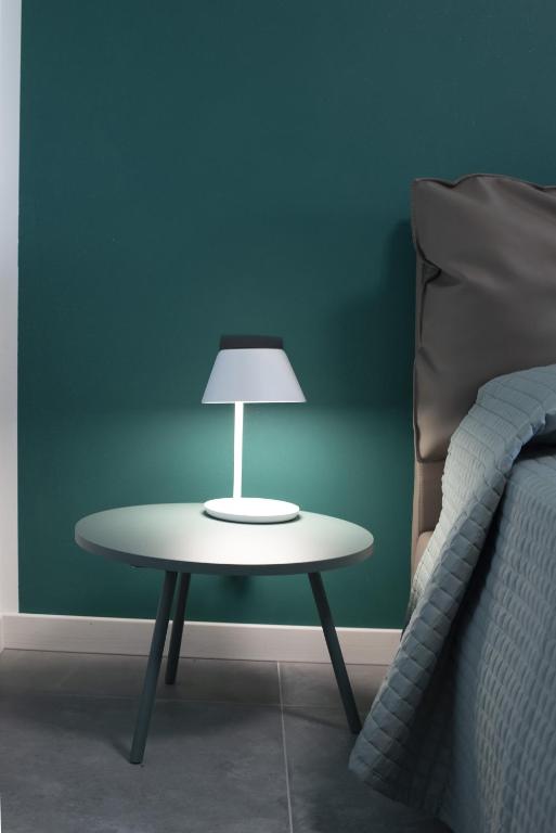 a table with a lamp on it next to a bed at B&B Lough in Colà di Lazise