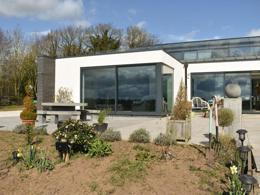 ein Haus mit vielen Fenstern und Pflanzen in der Unterkunft Park Barn in Whittington