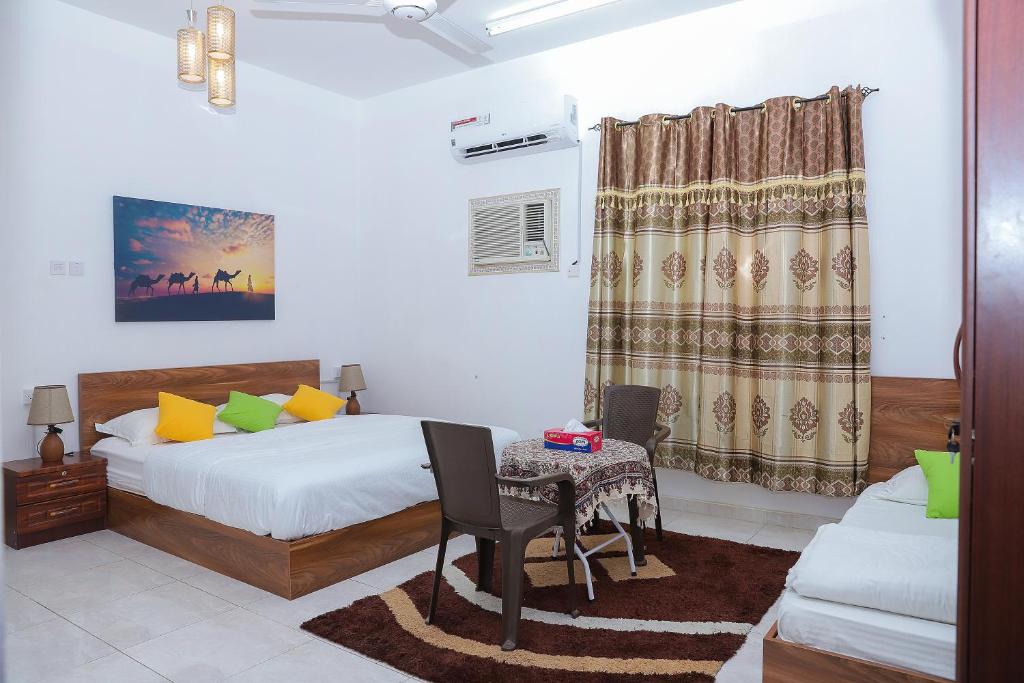 1 dormitorio con cama, mesa y sofá en Nima guest house, en Nizwa