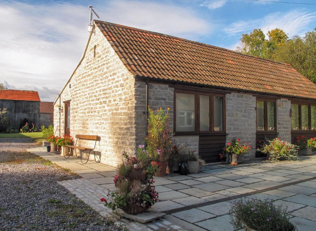 a small brick house with a bench in front of it at Cedar Barn in Alford