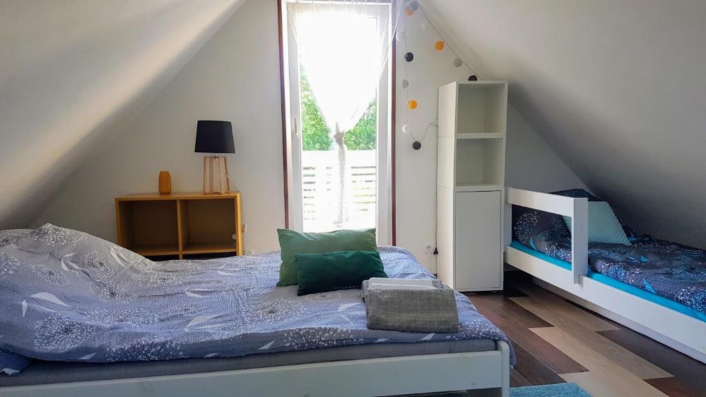 sypialnia z łóżkiem i schody z oknem w obiekcie Biały Domek koło Żywca w mieście Pewel Wielka