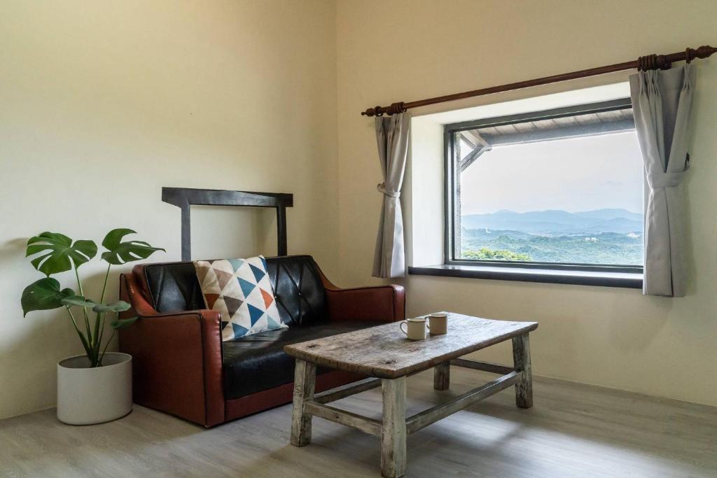 a living room with a chair and a table and a window at Sunny Room in Jiufen