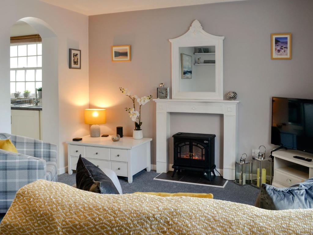 sala de estar con chimenea y TV en Nice Cottage In Gatehouse Of Fleet With 2 Bedrooms And Wifi en Gatehouse of Fleet