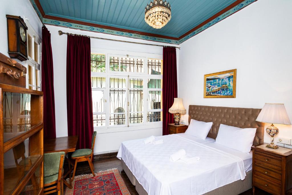 a bedroom with a bed and a window at Mansion with Lemon Tree in İzmir