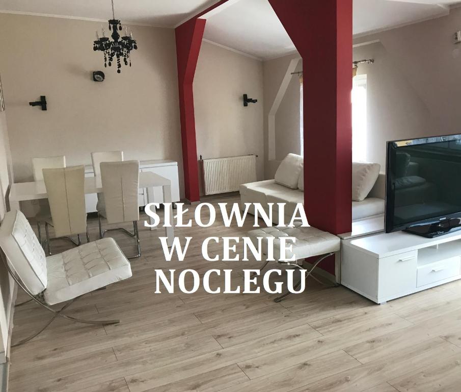 - un salon avec une table à manger et une télévision dans l'établissement Centrum Noclegowe II, à Bydgoszcz