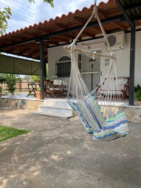a hammock hanging in front of a house at G&S Beach House in Flogita