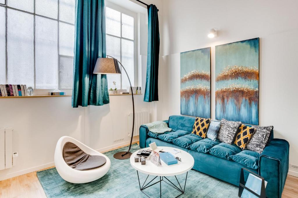 un soggiorno con divano blu e tavolo di Sweet Inn - Rue de Lallier a Parigi
