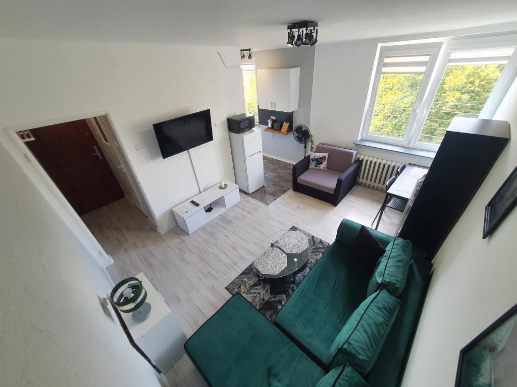 una vista aérea de una sala de estar con un sofá verde en Forest House, en Dębica