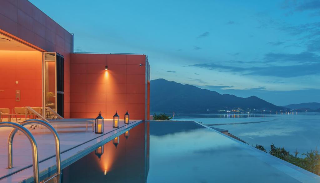 a swimming pool in front of a building with the water at Bayclub in Namhae