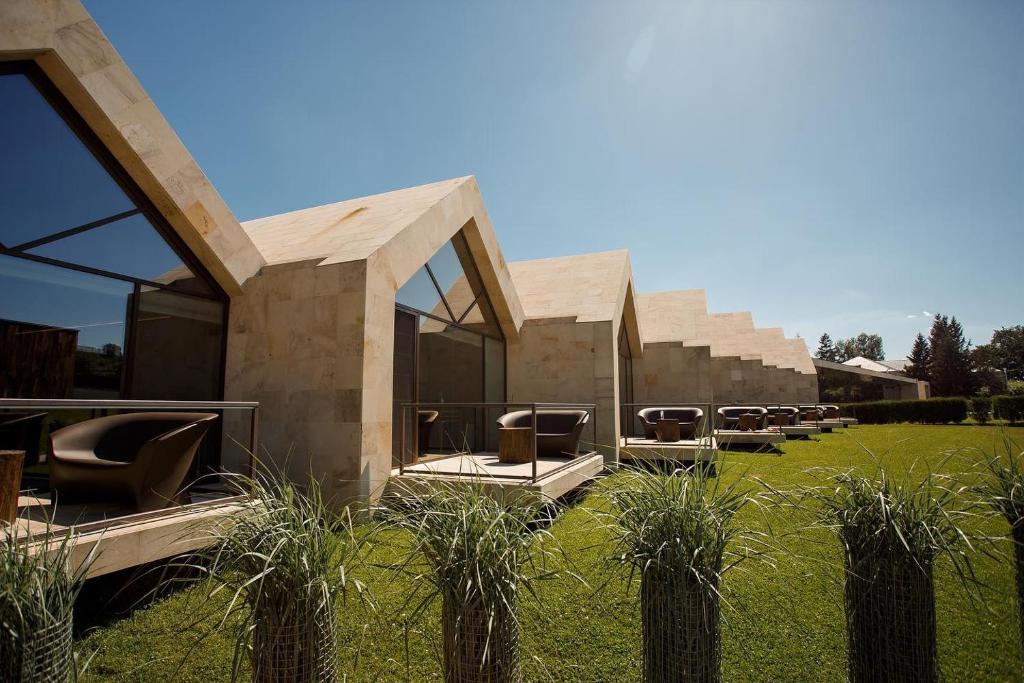 a building with a bunch of chairs in a field at Castel Mimi Boutique Hotel in Bulboaca