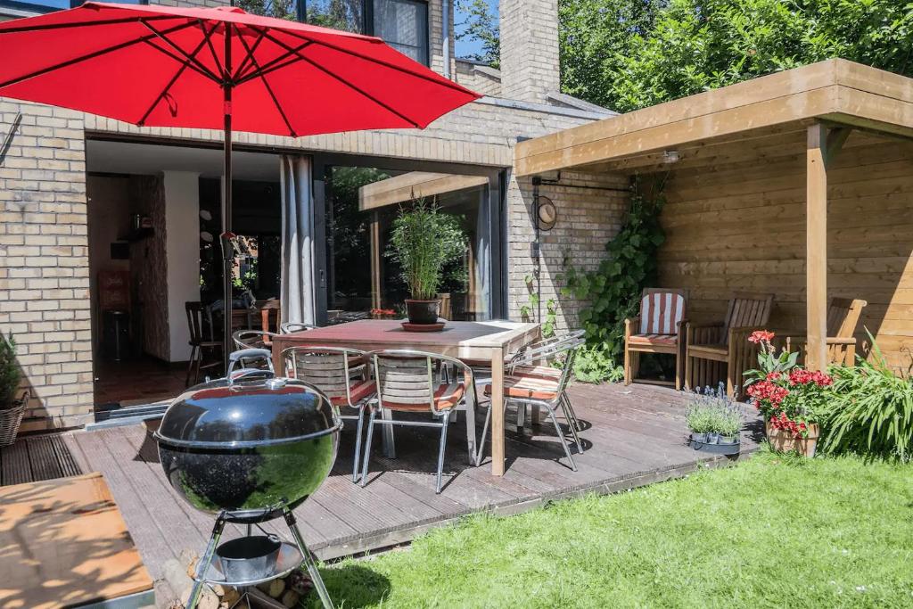 een patio met een barbecue en een tafel met een grill bij Holiday home Keysersnest in Gistel