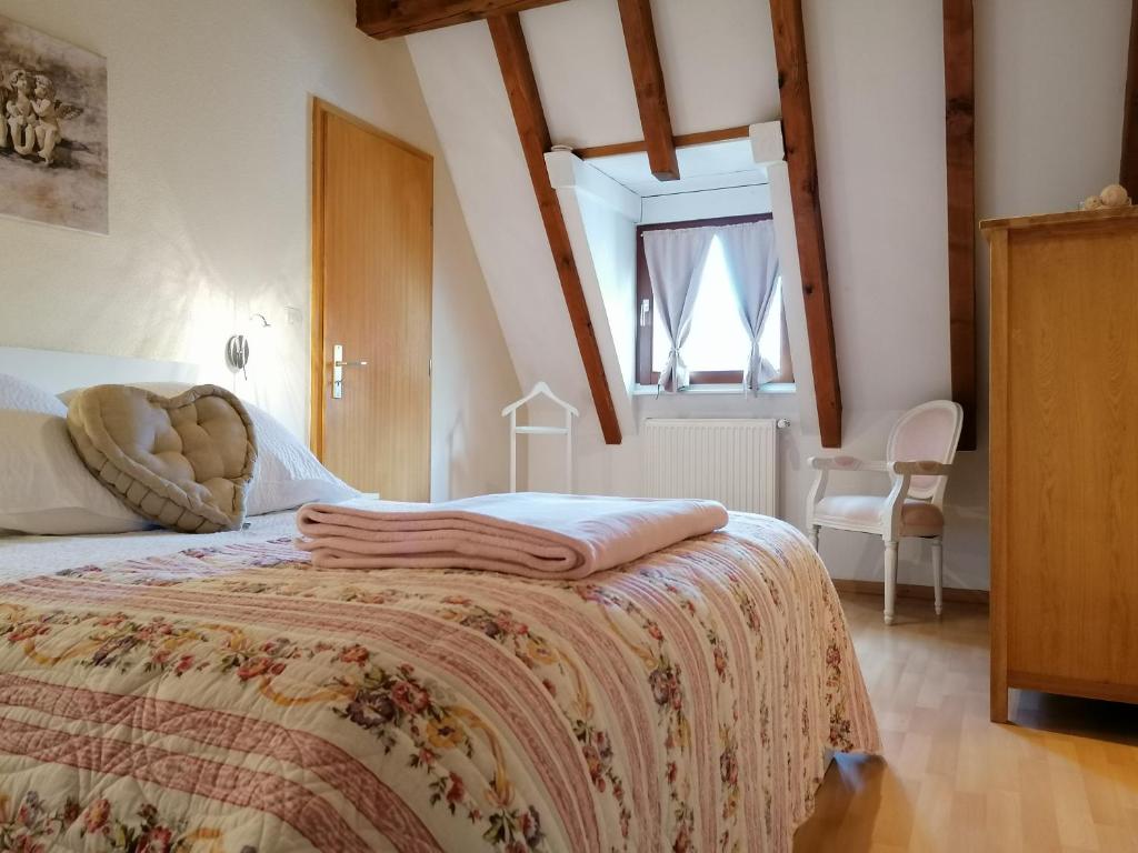 een slaapkamer met een bed en een raam bij Victor et Léontine in Ribeauvillé