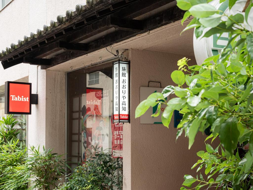 ein Gebäude mit Schildern an der Seite in der Unterkunft Tabist Ooriya Kochi in Sagamichō