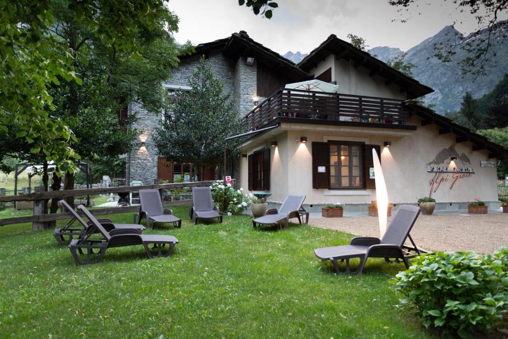 a group of chairs sitting in the grass in front of a house at Fermata Alpi Graie 