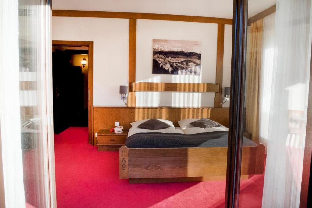 una camera con un grande letto e un tappeto rosso di Haus Kohl a Semmering