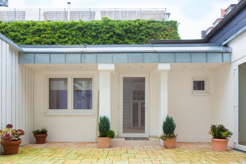 a white house with plants on the roof at Hotel Herzog in Düsseldorf