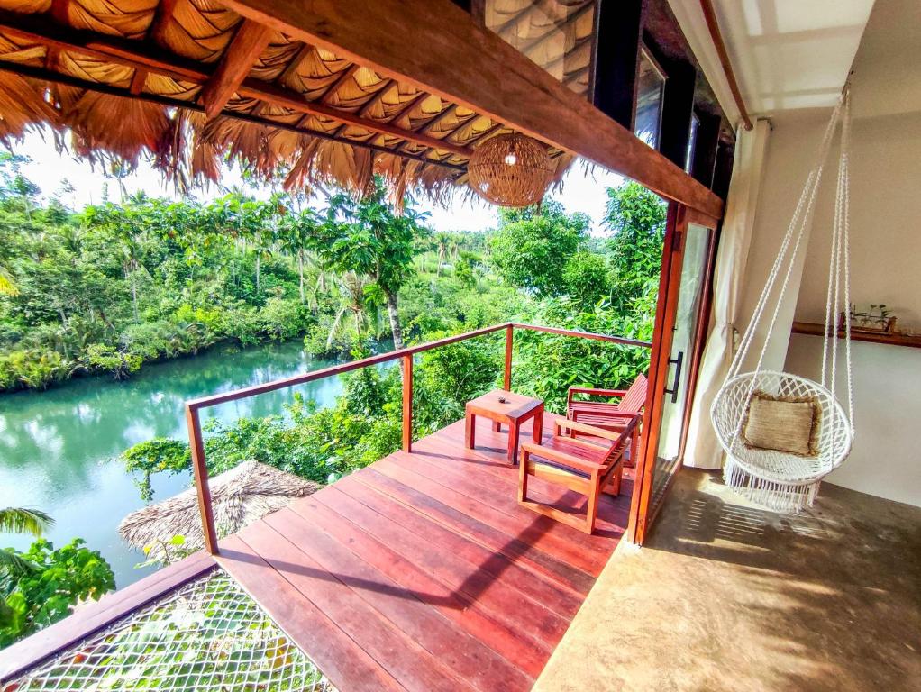 a porch with a swing and a view of a river at The River Hideaway in General Luna