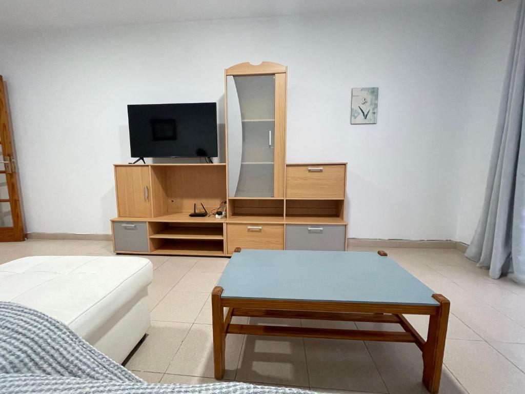 ein Wohnzimmer mit einem Couchtisch und einem TV in der Unterkunft Apartamento colón arinaga in Arinaga