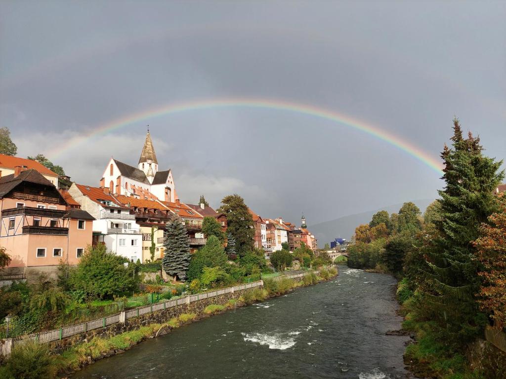 a rainbow over a river in a city at Das Eckhaus in Murau