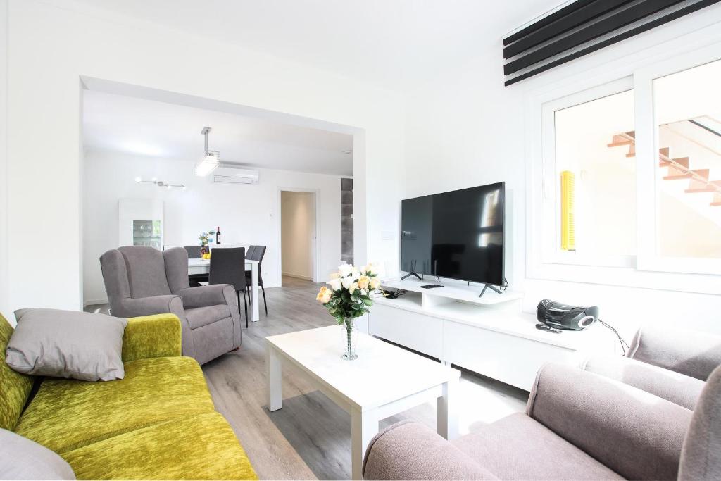 a living room with a couch and a tv at Apt RIERES in Port de Pollensa