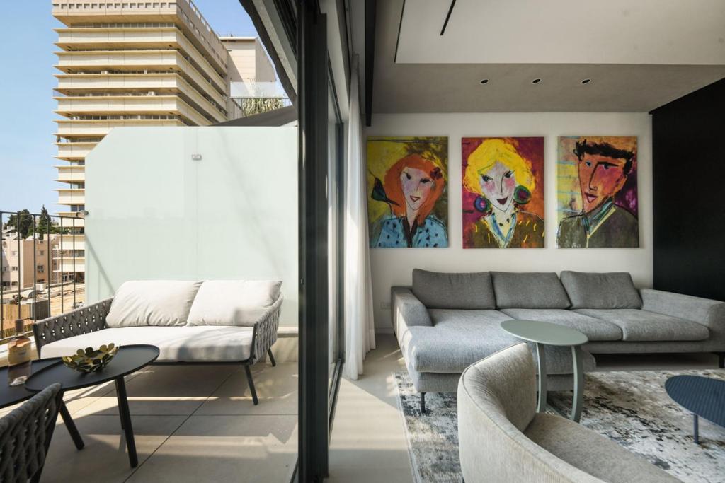 a living room with a couch and a table at Modern and Vibrant 2BR apartment with Private Balcony by Sea N' Rent in Tel Aviv