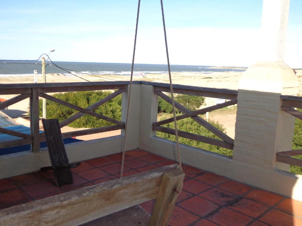 a balcony with a bench and a view of the beach at El Mirador in Punta Del Diablo