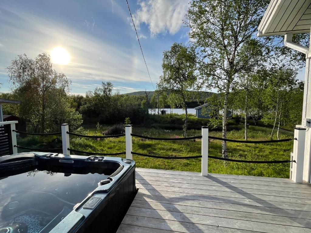 un bain à remous sur une terrasse à côté d'une clôture dans l'établissement Villa Arktika porealtaallinen mökki Nuorgamissa Tenojoen ja tunturien vieressä, à Nuorgam