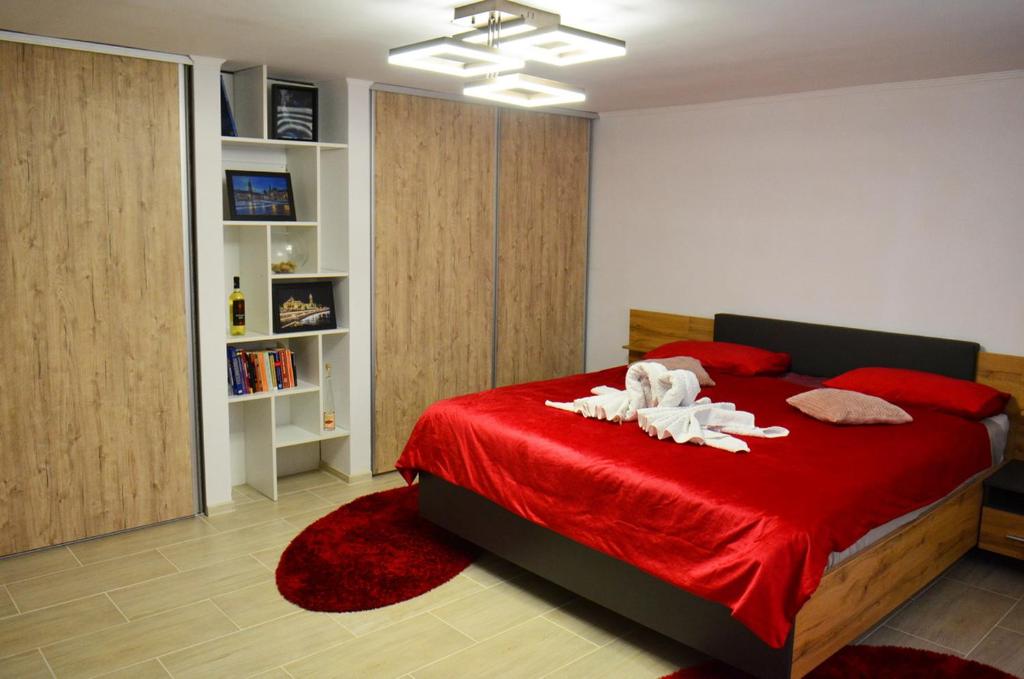 a bedroom with a red bed with two animals on it at Lovely 2 bedroom apartment in the City Centre of Oradea in Oradea