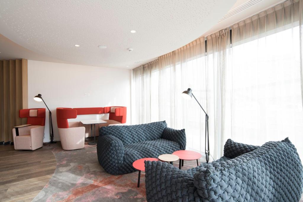 a living room with two couches and a table at Holiday Inn Express - Paris - CDG Airport by IHG in Roissy-en-France