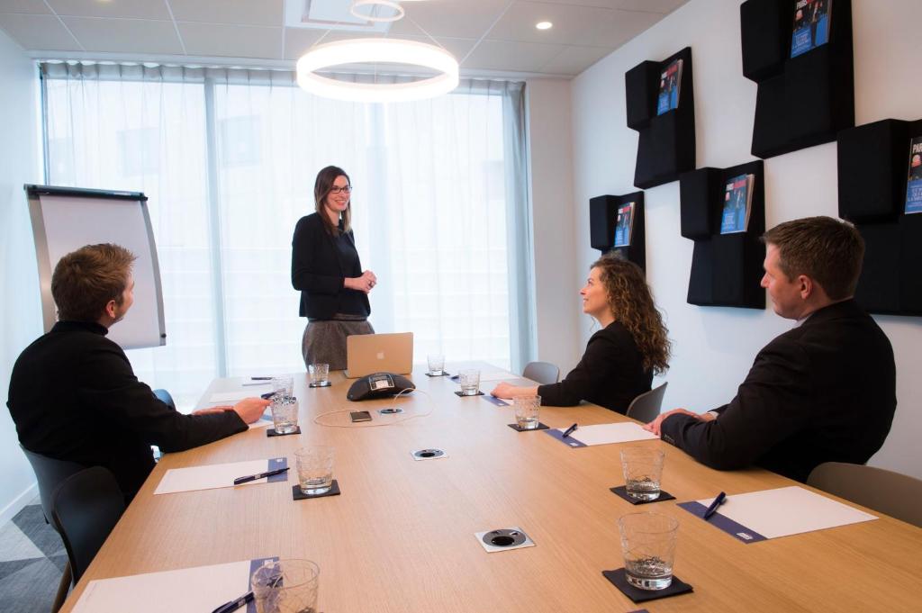 a group of people sitting around a table in a meeting room at Holiday Inn Express - Paris - CDG Airport by IHG in Roissy-en-France