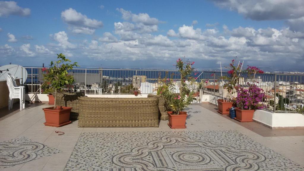 a balcony with potted plants and a view of a city at Apartment Haifa in Haifa