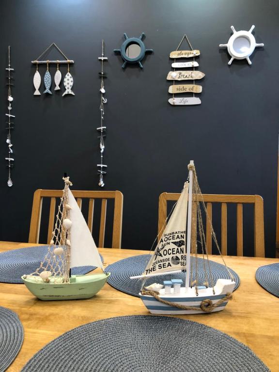 a wooden table with two toy boats on it at Apartment Windau in Ventspils