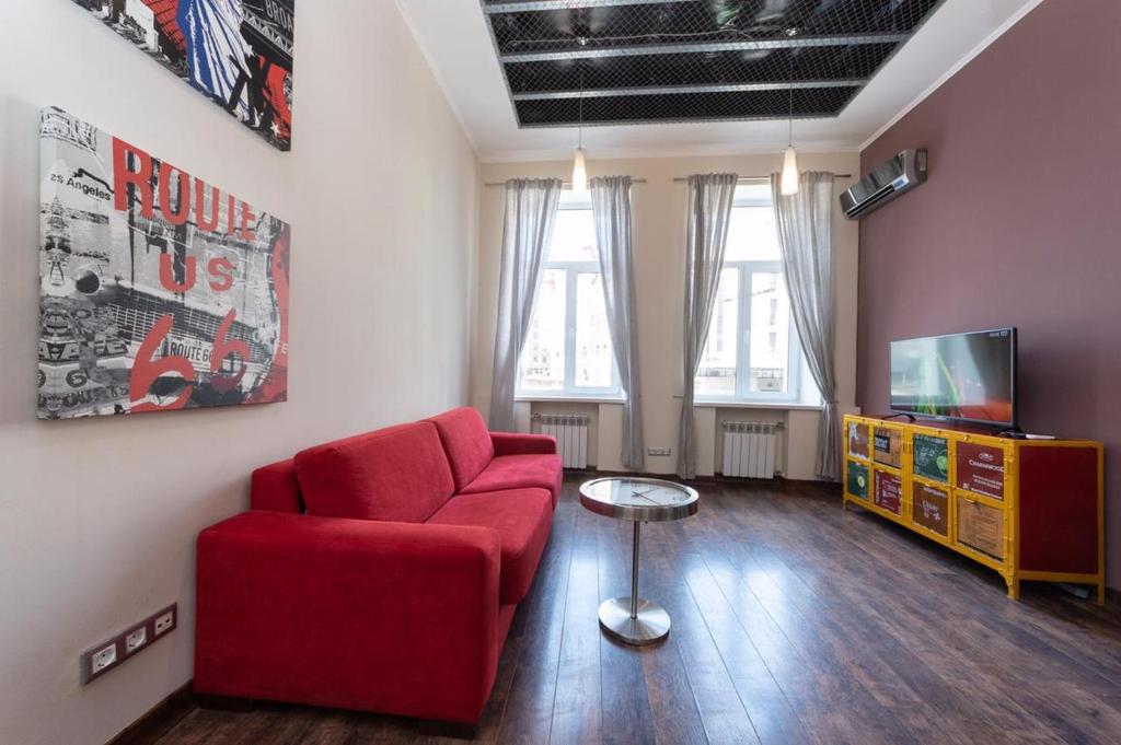 a living room with a red couch and a tv at Alex Apartments on Lva Tolstogo in Kyiv