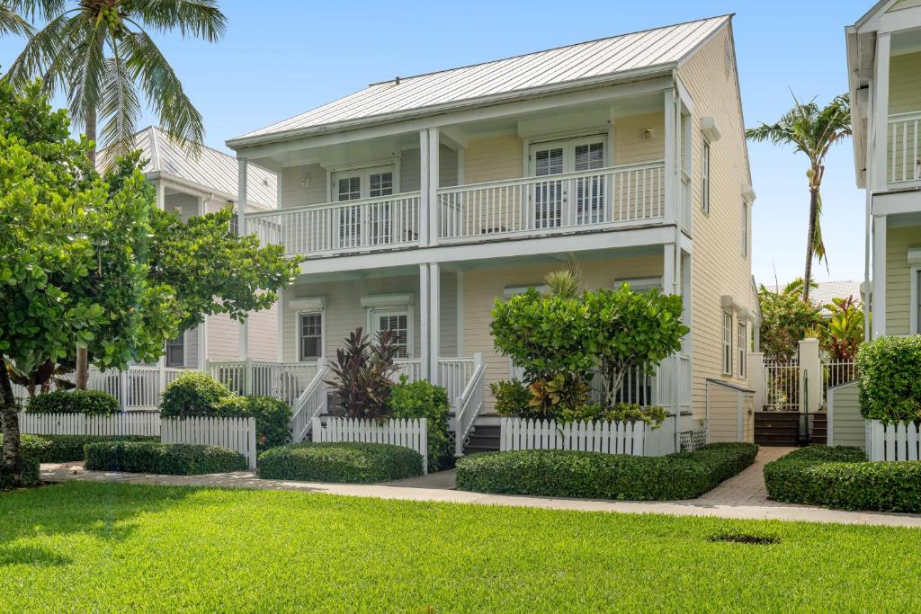 a large white house with trees and grass at Key Lime Villa in Duck Key