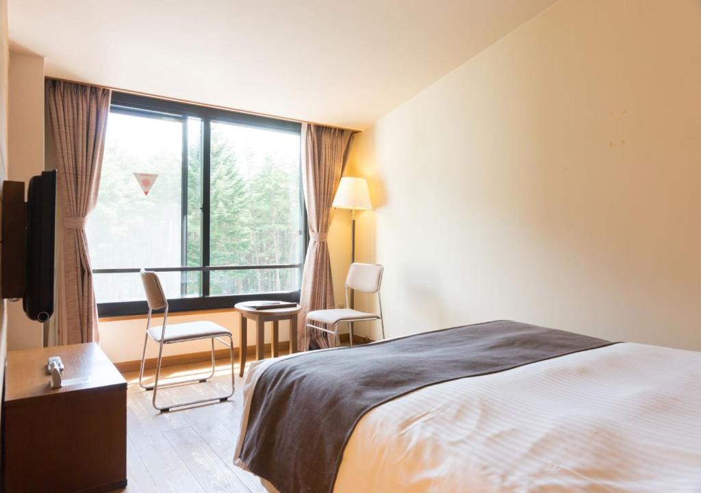 Postel nebo postele na pokoji v ubytování Yatsugatake Hotel Fuuka