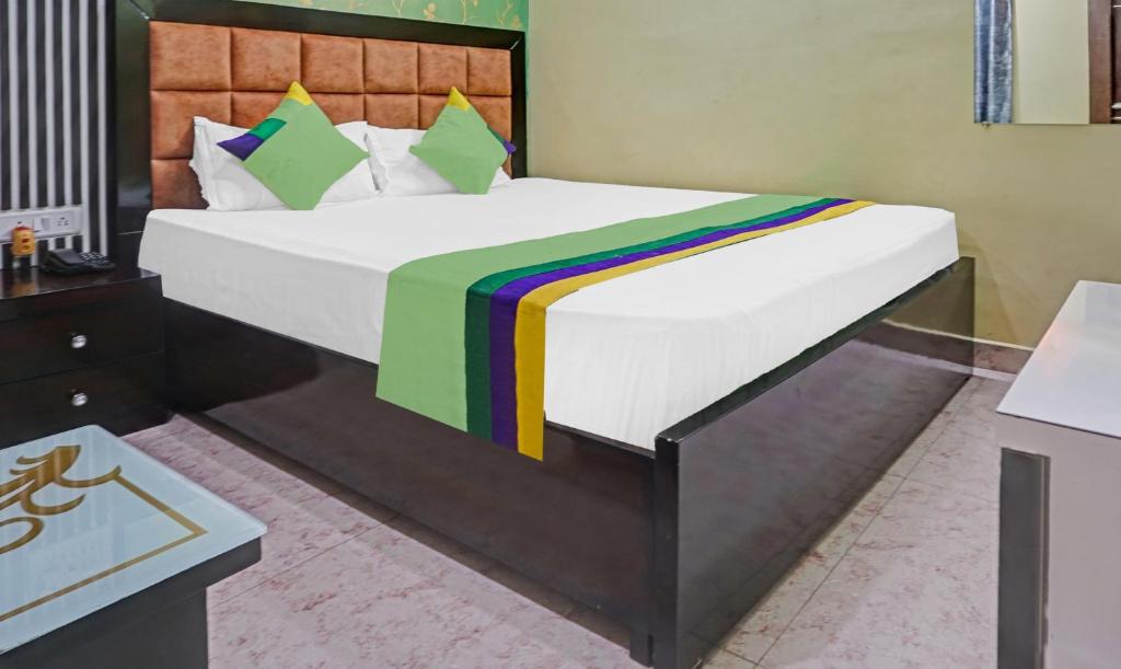 a bedroom with a large bed with a colorful blanket at Hotel Prem Residency in Patna