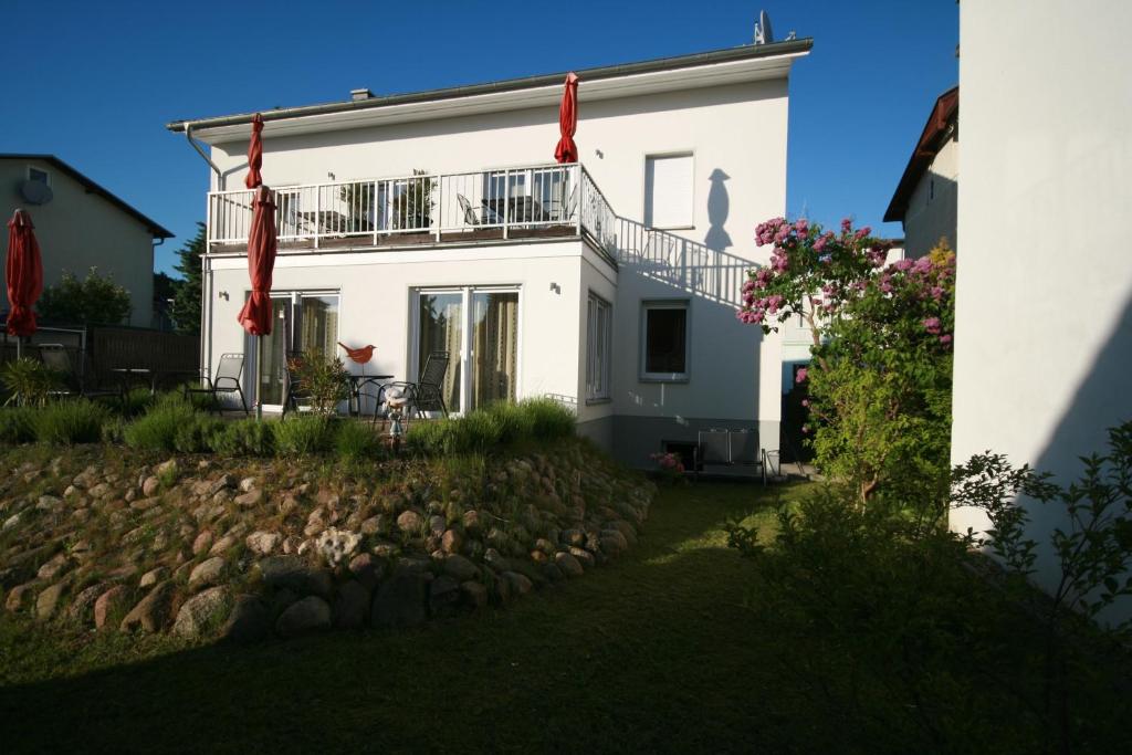 ein weißes Haus mit einem Balkon und einem Hof in der Unterkunft Haus Sandra in Sassnitz
