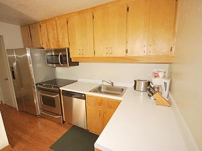 a kitchen with wooden cabinets and stainless steel appliances at Ala WaiApartment in South Lake Tahoe
