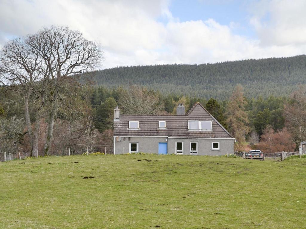 una grande casa su una collina in un campo di Half House a Nethy Bridge