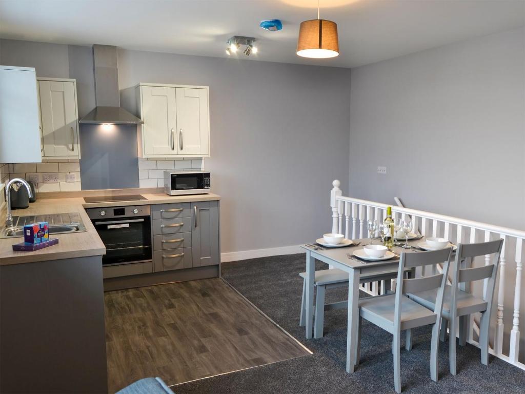 eine Küche mit einem Tisch, einem kleinen Tisch und Stühlen in der Unterkunft Apartment 3 The Beach Hut - Uk31822 in Great Yarmouth