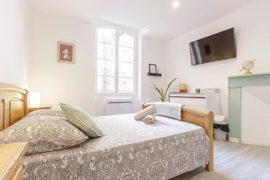 a bedroom with a bed and a tv on the wall at M Suites - Gaillac Centre in Gaillac