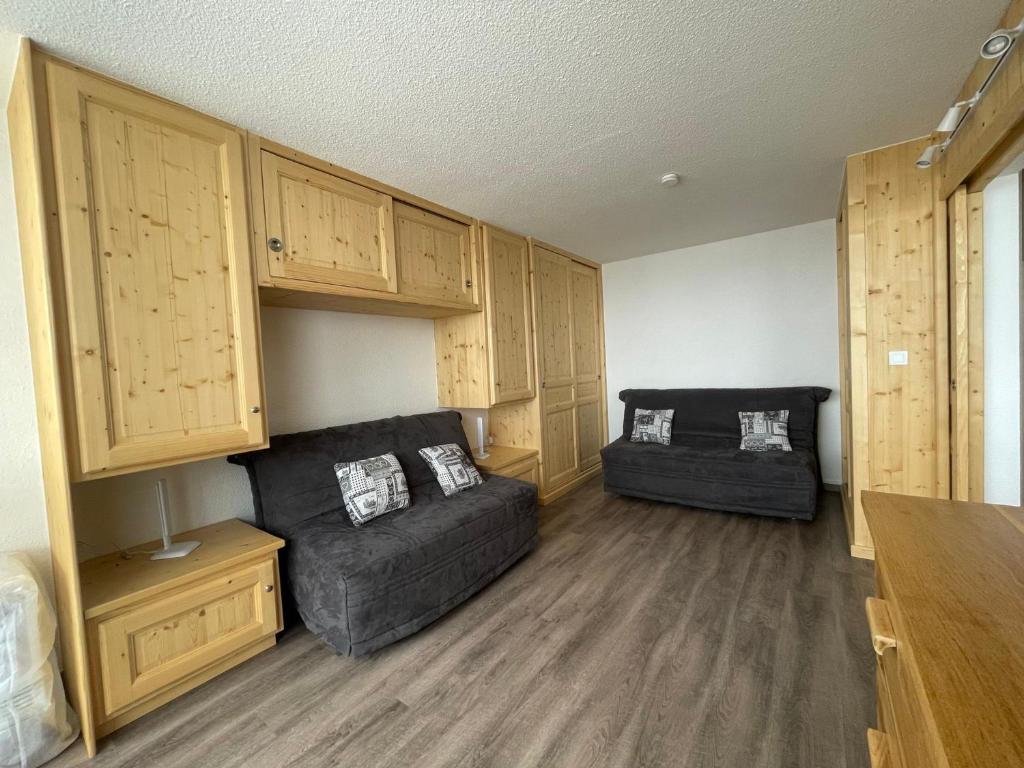 a living room with a couch and a chair at Appartement rénové au pied des pistes avec balcon exposé sud pour 4 personnes - FR-1-452-365 in Les Menuires