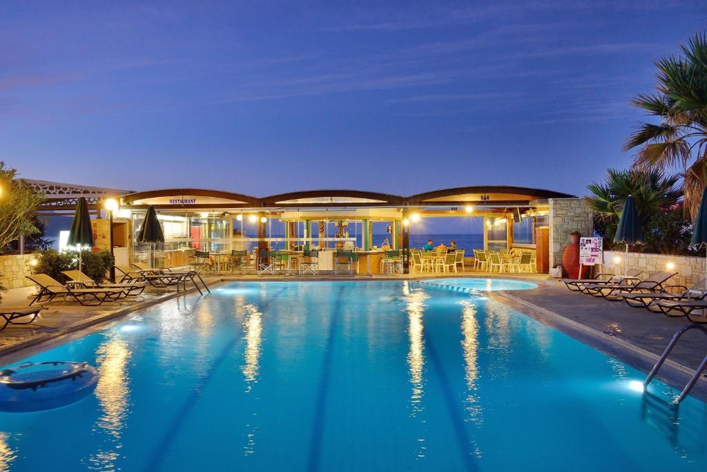 a large swimming pool in a resort at night at Nektar Beach Hotel in Stalos