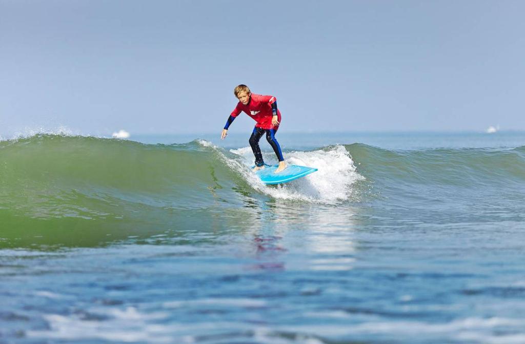 a man riding a wave on a surfboard in the ocean at Nature et decouverte a Brem sur Mer in Brem-sur-Mer
