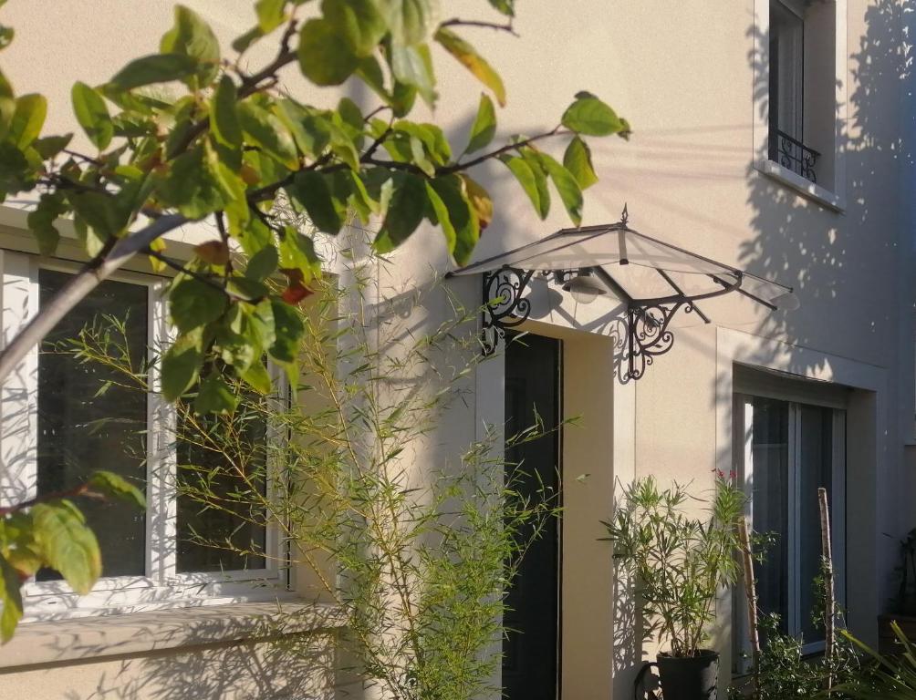 a building with an umbrella in front of a door at VILLA VOLTAIRE in Clamart